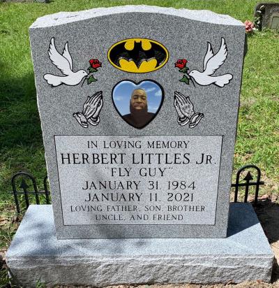 single gray granite upright headstone with batman symbol, doves, and praying hands